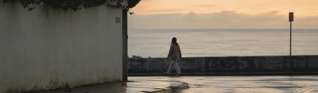 Woman walking along in an oceanfront town in the morning